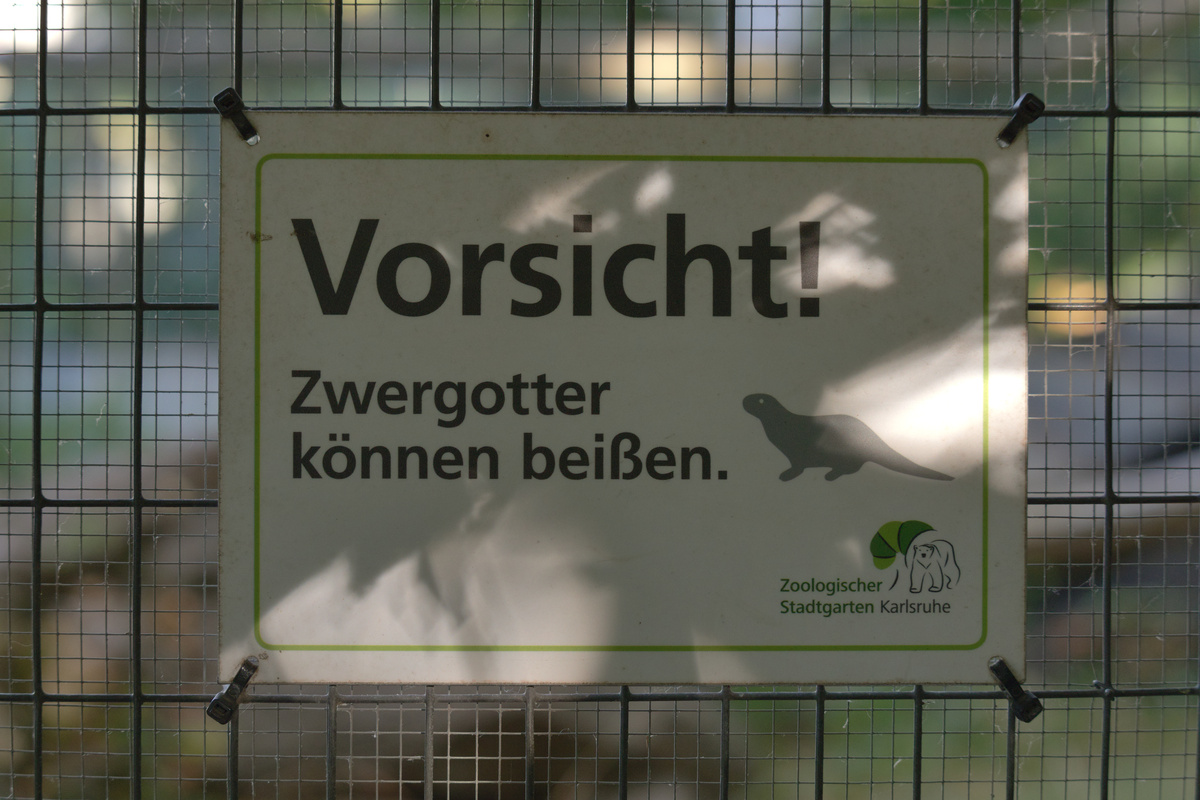 Ein Hinweisschild: Vorsicht! Zwergotter können beißen.