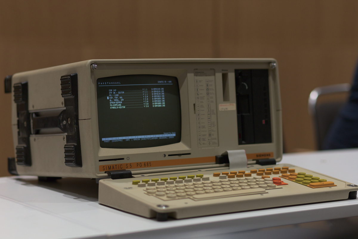 A Siemens Simatic S5 PG685 stands on a table. It shows a PAKETANWAHL screen with 8 different options.